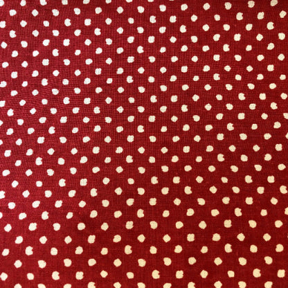 Red fabric with small white polka dots